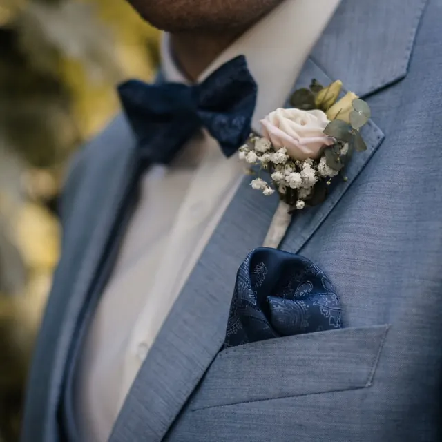 Bräutigam mit blauer Fliege und Ansteckblume