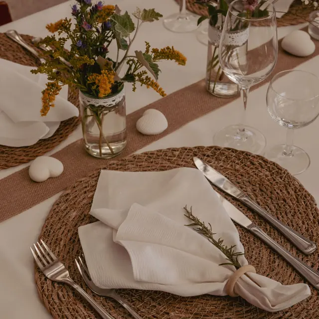 Tischdeko mit Serviette, Besteck und Wiesenblumen