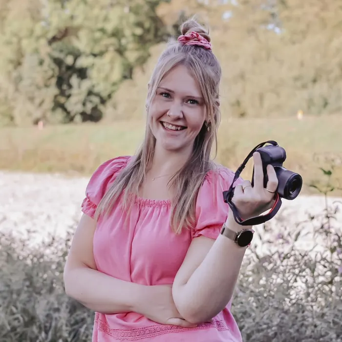 Miriam Gölzer, Fotografin in Freiburg, lacht mit ihrer Kamera in der Hand